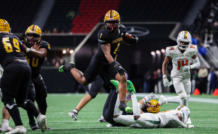 Perry's Ahmad Gordon (1) hurdles a Stockbridge defender during a run in the Georgia 4A state championship game. 12/12/2023